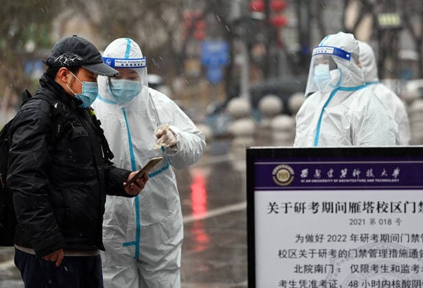 (211225) -- XI AN, Dec. 25, 2021 -- A staff member checks the nucleic acid test result of an examinee (1st L) for postgraduate entrance exams in Xi an, northwest China s Shaanxi Province, Dec. 25, 2021. Xi an imposed closed-off management for communities and villages on Thursday in an effort to curb the spread of the latest COVID-19 resurgence. More than 3,000 nucleic acid testing sites in Xi an are working simultaneously to provide services for residents in communities and on roadsides. Tens of thousands of frontline workers and volunteers are working against the clock to contain the virus. To swiftly contain the spread of the virus, local authorities have rolled out urgent measures while ensuring the city s residents have access 