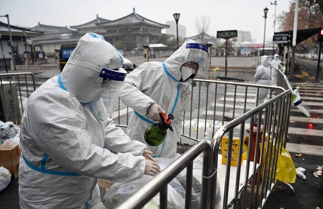(211225) -- XI AN, Dec. 25, 2021 -- Staff members disinfect packed vegetables at a residential area under quarantine in Xi an, northwest China s Shaanxi Province, Dec. 25, 2021. Xi an imposed closed-off management for communities and villages on Thursday in an effort to curb the spread of the latest COVID-19 resurgence. More than 3,000 nucleic acid testing sites in Xi an are working simultaneously to provide services for residents in communities and on roadsides. Tens of thousands of frontline workers and volunteers are working against the clock to contain the virus. To swiftly contain the spread of the virus, local authorities have rolled out urgent measures while ensuring the city s residents have access to daily necessities. ) 