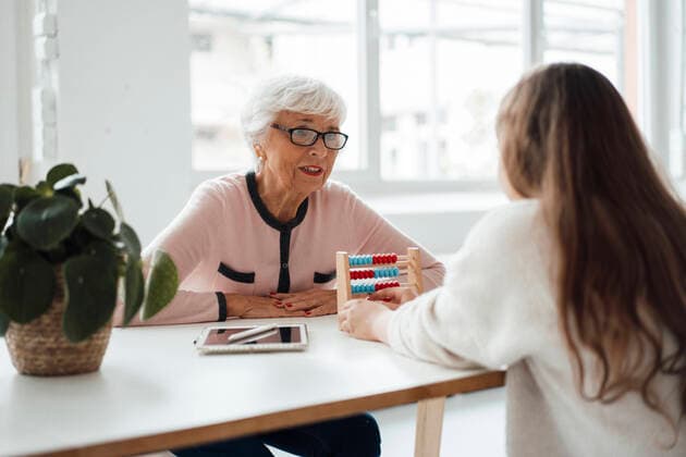 Grandmother talking to granddaughter playing with abacus at home model released property released, JOSEF05969