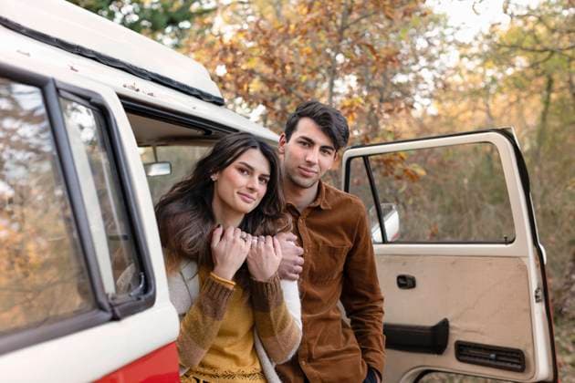 IMAGO Creative: Herbst, Touren mit dem Camper Young man embracing girlfriend at motor home model released, EIF02477