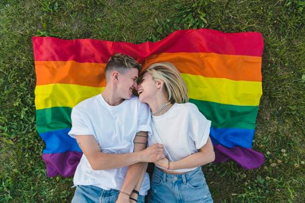Happy romantic young couple relaxing on rainbow flag model released property released, MGIF01195