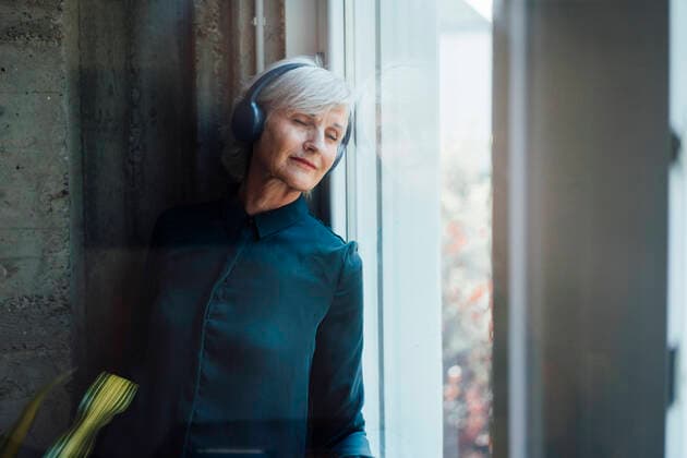 Businesswoman listening music through wireless headphones in office model released property released, JOSEF06050