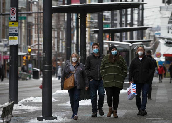 (211227) -- VANCOUVER, Dec. 27, 2021 -- People wearing face masks walk on a street in Vancouver, British Columbia, Canada, on Dec. 27, 2021. Canada reported 18,230 new COVID-19 cases Monday noon, elevating the cumulative whole to 2,026,249 cases with 30,172 deaths, according to CTV. (Photo by Xinhua) CANADA-VANCOUVER-COVID-19-CASES-2 MLN LiangxSen