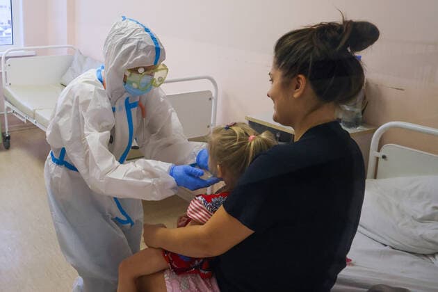 ST PETERSBURG, RUSSIA â€“ DECEMBER 29, 2021: A medical worker attends a patient with a child in the red zone of a COVID-19 ward at the Filatov children s city clinical hospital No 5 treating young COVID-19 patients. Peter Kovalev TASS  TS11DAD7