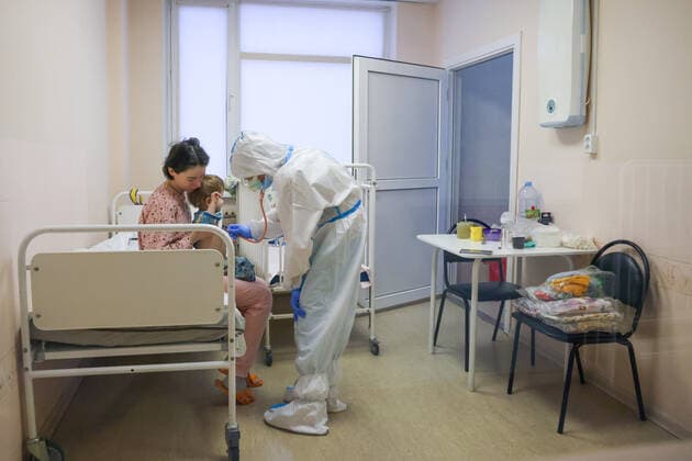 ST PETERSBURG, RUSSIA â€“ DECEMBER 29, 2021: A medical worker attends a patient with a child in the red zone of a COVID-19 ward at the Filatov children s city clinical hospital No 5 treating young COVID-19 patients. Peter Kovalev TASS  TS11DADF