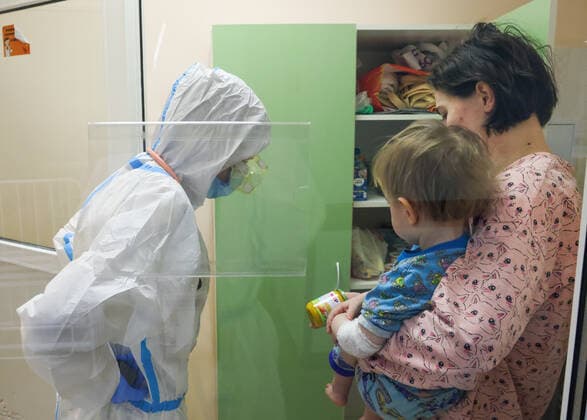 ST PETERSBURG, RUSSIA â€“ DECEMBER 29, 2021: A medical worker attends a patient with a child in the red zone of a COVID-19 ward at the Filatov children s city clinical hospital No 5 treating young COVID-19 patients. Peter Kovalev TASS  TS11DAE0