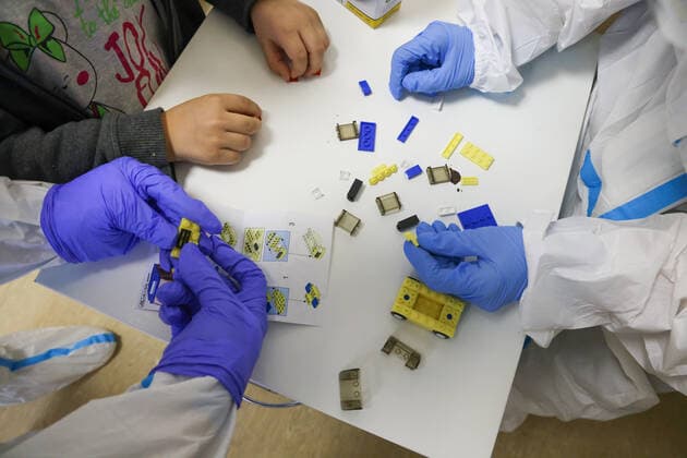 ST PETERSBURG, RUSSIA â€“ DECEMBER 29, 2021: Medical workers and a patient play with Lego bricks in the red zone of a COVID-19 ward at the Filatov children s city clinical hospital No 5 treating young COVID-19 patients. Peter Kovalev TASS  TS11DAE8