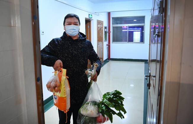 (211229) -- XI AN, Dec. 29, 2021 -- A community worker delivers daily necessities to a household under closed-off management in Xi an, capital of northwest China s Shaanxi Province, Dec. 29, 2021. Authorities in Xi an have upgraded epidemic control and prevention measures starting Monday, ordering all residents to stay indoors and refrain from gatherings except when taking nucleic acid tests. Daily necessities of residents were guaranteed every day through delivery services. ) CHINA-SHAANXI-XI AN-COVID-19-DAILY SUPPLIES DELIVERY (CN) TaoxMing 