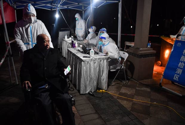 (220101) -- XI AN, Jan. 1, 2022 -- A volunteer helps a senior take nucleic acid test at a residential area in Xi an, northwest China s Shaanxi Province, Dec. 31, 2021. Staff members and volunteers stuck to their posts on the New Year s eve to ensure supplies of daily necessities for the residents under lockdown and help contain the COVID-19 resurgence in Xi an. ) CHINA-SHAANXI-XI AN-COVID-19-NEW YEAR S EVE (CN) ZhangxBowen 