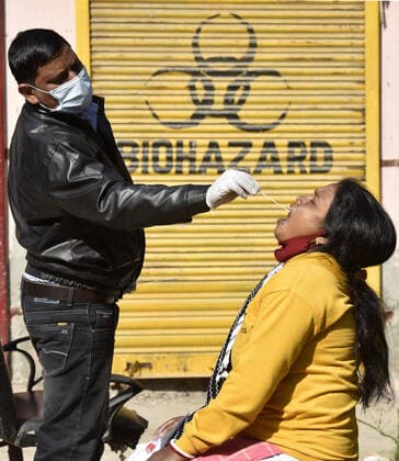 Coronavirus, Eindrücke aus Indien NOIDA, INDIA - JANUARY 4: A health worker collects a swab sample for Covid-19 test, at CHC Bhangel, Sector 102, on January 4, 2022 in Noida, India. (Photo by Sunil Ghosh Hindustan Times ) Daily Life Amid Coronavirus Pandemic In India
