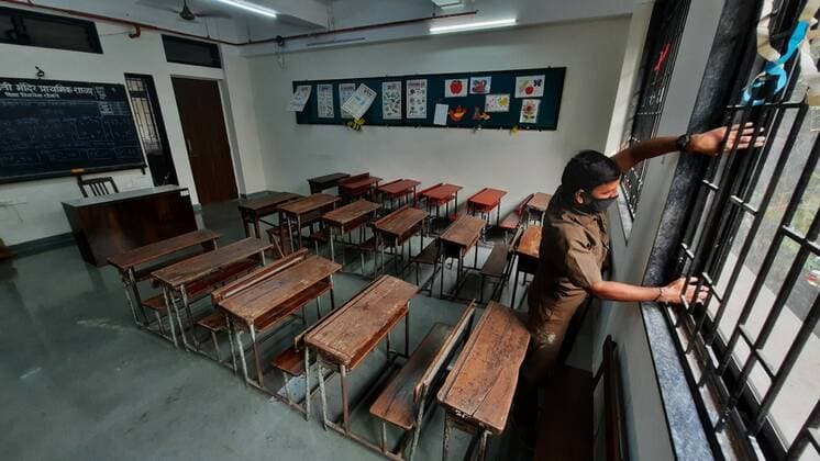Coronavirus, Eindrücke aus Indien MUMBAI, INDIA - JANUARY 4: A school staff seen closing a deserted and empty classroom after Maharastra government announced to close Classes 1-9 and 11 till 31st January due to the increase in Covid-variant Omicron patients amid third wave threat, in Thane, on January 4, 2022 in Mumbai, India. (Photo by Praful Gangurde Hindustan Times ) Daily Life Amid Coronavirus Pandemic In India
