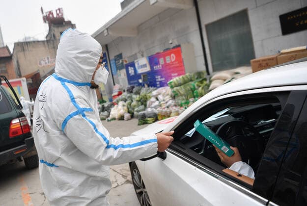 (220105) -- XI AN, Jan. 5, 2022 -- Xu Kai gives face masks to a volunteer in Yanta District of Xi an, northwest China s Shaanxi Province, Jan. 5, 2022. Located in Yanta District of Xi an, Deshan shared kitchen was run as an anti-cancer kitchen , providing convenience for cancer patients and their families to cook meals. Xu Kai, founder of the shared kitchen, transformed this anti-cancer kitchen into a fight-against-epidemic kitchen after the city has been hit by the recent COVID-19 resurgence. Up to now, more than 30 volunteers have joined the food delivery activities of the kitchen to help not only cancer patients and their families who are stranded in Xi an, but also some personnel who work for the prevention and control of the CO