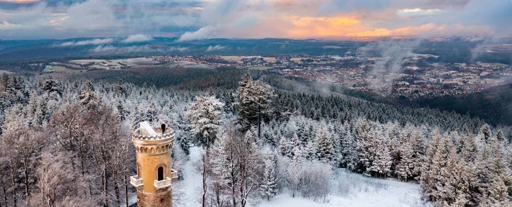 Biosphärenreservat Thüringer Wald - Kickelhahn Wanderer blicken vom Aussichtsturm auf dem Kickelhahn über schneebedeckte Bäume auf die Stadt Ilmenau. Der Berg liegt im UNESCO-Biosphärenreservat Thüringer Wald. Das Bild wurde mit einer Fotodrohne aufgenommen. Ilmenau Thüringen DEUTSCHLAND *** Biosphere Reserve Thuringian Forest Kickelhahn Hikers look from the observation tower on the Kickelhahn over snow-covered trees to the city of Ilmenau The mountain is located in the UNESCO Biosphere Reserve Thuringian Forest The picture was taken with a photo drone Ilmenau Thuringia GERMANY
