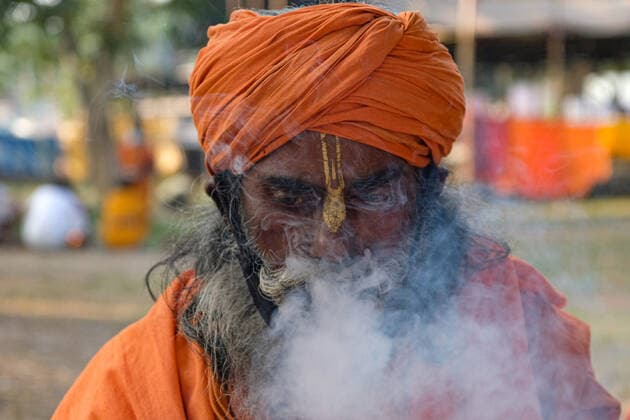 January 7, 2022, Kolkata, WEST BENGAL, INDIA: January 07, 2022, Kolkata, West Bengal, India: A sadhu is smoking at the Gangasagar transit camp, Kolkata.. Gangasagar mela preparations was on hold due to a petition urging to stop this year s annual pilgrimage fair in light of the COVID-19 Omicron numbers in West Bengal and in the country at large. Calcutta High Court gave a go-ahead to Gangasagar Mela with certain restrictions on 7th January whereas India reported 117100 new covid cases and 302 fatalities in last 24 hours as per Indian media reports. Kolkata INDIA - ZUMAb206 20220107_zip_b206_004 Copyright: xDipayanxBosex