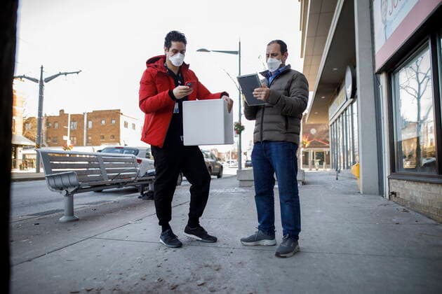 January 7, 2022, TORONTO, ON, CANADA: Dr. Nathan Stall, left, and Toronto city councilor Josh Matlow work out logistics between home visits as they bring third doses of the COVID-19 vaccine to homebound residents and their caregivers in Toronto, Friday, Jan. 7, 2022. The pair are working against lowering the barriers to getting the most vulnerable boosted with their third dose. TORONTO CANADA  - ZUMAc35_ 20220107_zaf_c35_024 Copyright: xColexBurstonx