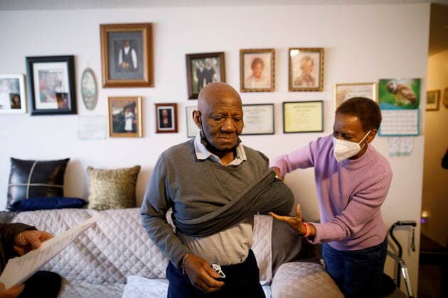 January 7, 2022, TORONTO, ON, CANADA: Yvonne Yorke helps her stepdad Neville Williams as Dr. Nathan Stall and Toronto city councilor Josh Matlow bring third doses of the COVID-19 vaccine to homebound seniors and their caregivers in Toronto, Friday, Jan. 7, 2022. The pair are working against lowering the barriers to getting the most vulnerable boosted with their third dose. TORONTO CANADA  - ZUMAc35_ 20220107_zaf_c35_026 Copyright: xColexBurstonx