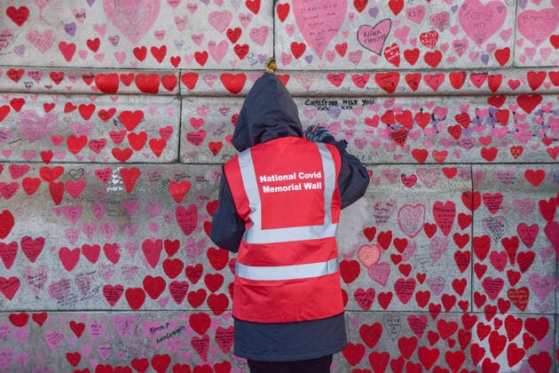 January 7, 2022, London, United Kingdom: A volunteer repaints the hearts on the National Covid Memorial Wall. ?.Volunteers, many of whom have lost family members to coronavirus, are repainting some of the red hearts which have faded over time. Over 150,000 hearts have been painted to date on the wall outside St Thomas Hospital opposite the Houses of Parliament, one for each life lost to COVID-19. London United Kingdom - ZUMAs197 20220107_zaa_s197_046 Copyright: xVukxValcicx