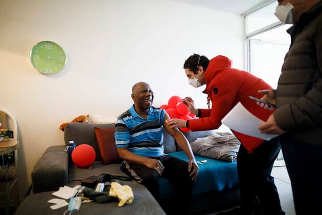 January 7, 2022, TORONTO, ON, CANADA: Dr. Nathan Stall administers a third dose of the COVID-19 vaccine to 77-year-old Vernal Davis as Dr. Stall and Toronto city councilor Josh Matlow bring third doses of the COVID-19 vaccine to homebound seniors and their caregivers in Toronto, Friday, Jan. 7, 2022. The pair are working against lowering the barriers to getting the most vulnerable boosted with their third dose. TORONTO CANADA  - ZUMAc35_ 20220107_zaf_c35_029 Copyright: xColexBurstonx