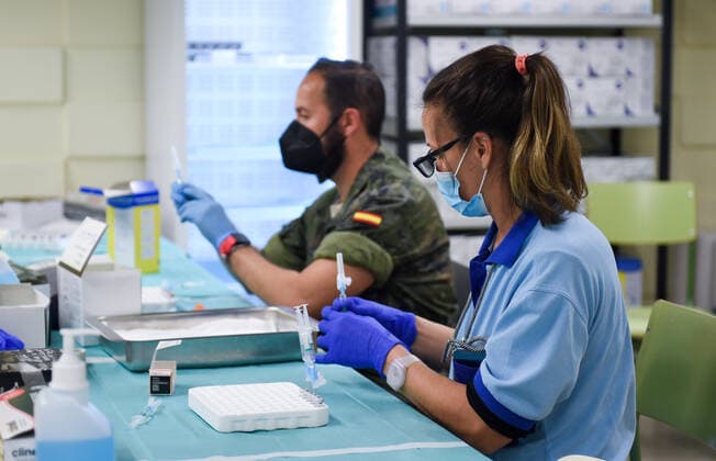 (220108) -- SEVILLE, Jan. 8, 2022 -- Hospital and military personnels work at a vaccination point in Seville University in Seville, Spain, on Jan. 7, 2022. The Spanish Ministry of Health registered 242,440 new cases of the virus from Wednesday to Friday, taking the total number of infections to 7,164,906 in Spain since the start of the pandemic. The Defense Ministry military continue to supply personnel to help with contact tracing and vaccination. (Photo by Xinhua) SPAIN-COVID-19-CASES GustavoxValiente 