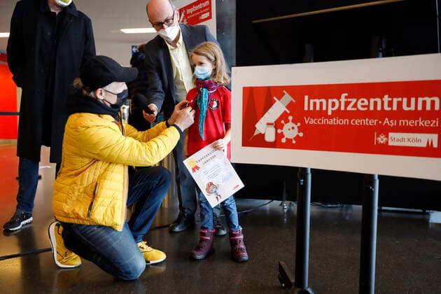 Thomas Baumgärtel and Dr Johannes Nießen with a fully vaccinated child with a certificate of bravery at the presentation of the buttons with the vaccination banana in the vaccination center of the city of Cologne in the Lanxess Arena Here, children 5 11 years are also vaccinated Foto:xC.xHardtx xFuturexImage