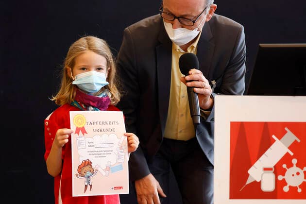 Dr Johannes Nießen with a fully vaccinated child with a certificate of bravery at the presentation of Thomas Baumgärtels buttons with the vaccination banana at the Vaccination Center of the City of Cologne in the Lanxess Arena Here, children 5 11 years are also vaccinated Fully Foto:xC.xHardtx xFuturexImage