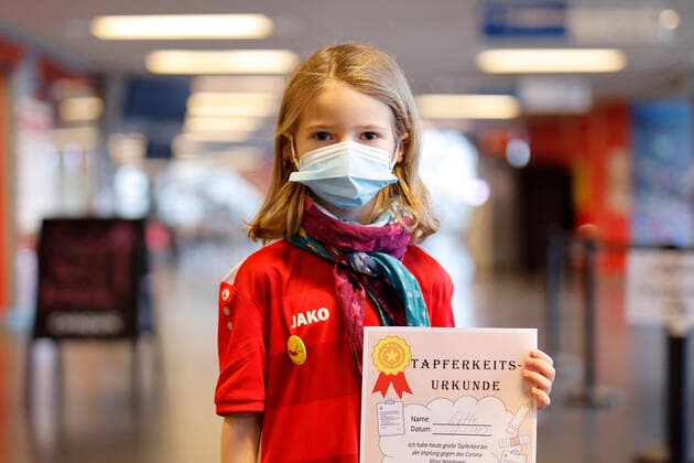 A fully vaccinated child with a certificate of bravery at the presentation of Thomas Baumgärtels buttons with the vaccination banana at the vaccination center of the city of Cologne in the Lanxess Arena Here, children 5 11 years are also vaccinated Fully vaccinated children receive a button as a gift as Foto:xC.xHardtx xFuturexImage