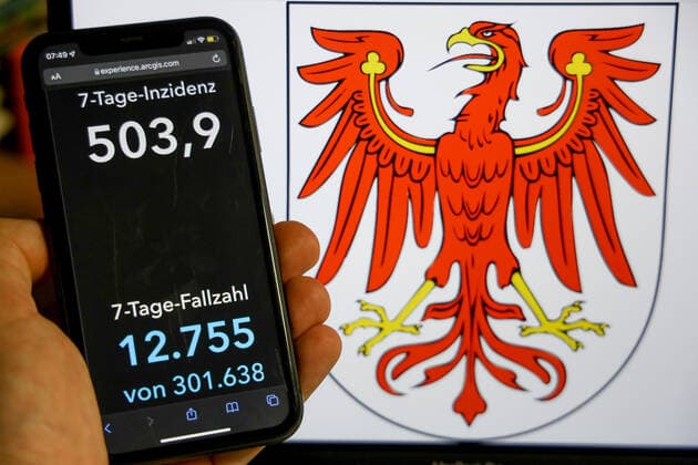 Coronavirus in Germany Covid 19 Dashboard of the Robert Koch Institute DEU, Germany, Brandenburg 09 01 2022 The 7-day incidence for the state Cases last 7 days 100 000 PE is displayed on an iPhone, with the state coat of arms in the background.