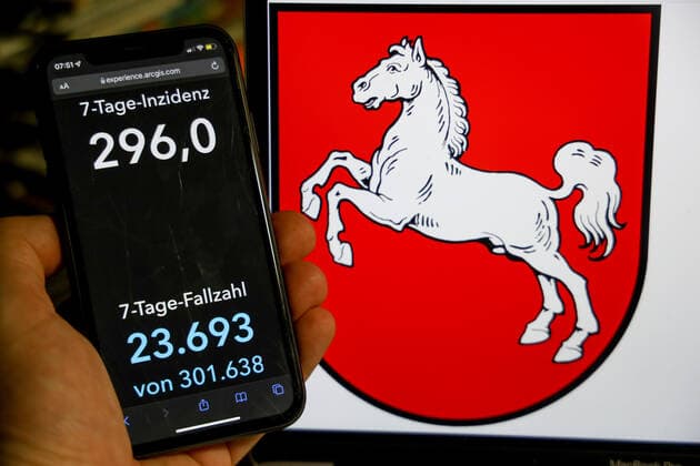 Coronavirus in Germany Covid 19 Dashboard of the Robert Koch Institute DEU, Germany, Lower Saxony 09 01 2022 The 7-day incidence for the state Cases last 7 days 100 000 p.e. is displayed on an iPhone, in the background the state coat of arms