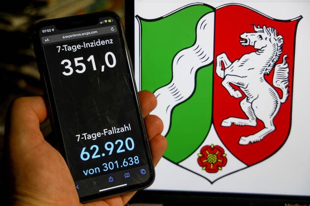 Coronavirus in Germany Covid 19 Dashboard of the Robert Koch Institute DEU, Germany, North Rhine Westphalia 09 01 2022 The 7-day incidence for the state Cases last 7 days 100 000 p.e. is displayed on an iPhone, with the state coat of arms in the background