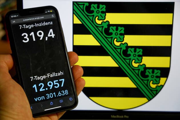 Coronavirus in Germany Covid 19 Dashboard of the Robert Koch Institute DEU, Germany, Saxony 09 01 2022 The 7-day incidence for the state Cases last 7 days 100 000 p.e. is displayed on an iPhone, in the background the state coat of arms
