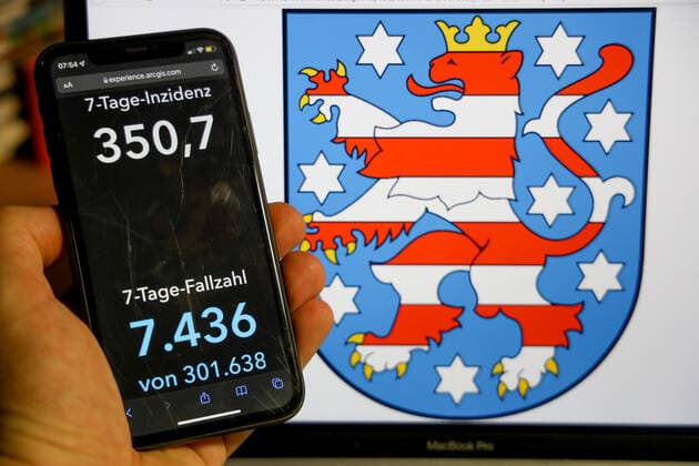 Coronavirus in Germany Covid 19 Dashboard of the Robert Koch Institute DEU, Germany, Thuringia 09 01 2022 The 7-day incidence for the state Cases last 7 days 100 000 p.e. is displayed on an iPhone, in the background the state coat of arms
