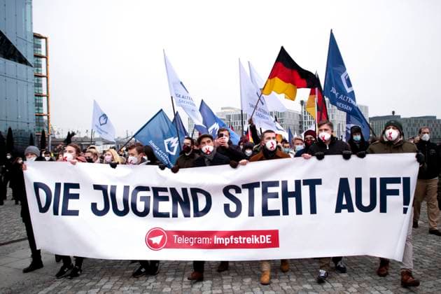 Protest AfD - Gegen Impfplicht DEU, Deutschland, Germany, Berlin, 11.12.2021 Demonstrant mit Transparent Die Jugend Steht Auf Telegram Impfstreik auf einer Kundgebung und Demonstration der Jungen Alternative JA, die Jugendorganisation‹ der rechtsextremen Partei Alternative fuer Deutschland AfD gegen eine Impfpflicht und die Coronapolitik der Bundesregierung unter dem Motto Impfstreik Deutschland im Regierungsviertel in Berlin. Der Protest ist gegen das Impfen gegen Corona Covid-19 und eine moegliche Impfpflicht wird unterstuetzt von sog. Querdenker und Rechtsradikalen. Junge Alternative fuer Deutschland. en: Protester with banner The youth stands up on Telegram vaccination strike at a rally and demonstration by the Junge Alternative JA, t