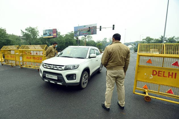NOIDA, INDIA JANUARY 9: Police personnel screen vehicles near Noida Gate during weekend curfew imposed by the Delhi government in wake of rising coronavirus cases, at Sector 14A, on January 9 2022 in Noida, India. (Photo by Sunil Ghosh Hindustan Times ) Delhi Imposes Weekend Curfew To Curb Covid-19 Spread