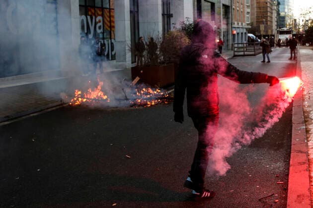 January 9, 2022, Brussels, Belgium: A protester holds a flare next to a burned tree during a demonstration against mandatory Covid-19 vaccination and other government measures to contain the spread of Covid-19 in Brussels, Belgium, January 9, 2022. Brussels Belgium - ZUMAm177 20220109_zip_m177_002 Copyright: xValeriaxMongellix