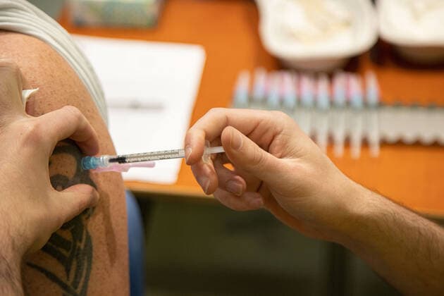 Booster Vaccination Against COVID In The Netherlands Closeup at the arm with a tatoo during the vaccination of a man. Vaccination center in Eindhoven with 20 lanes and the capacity of 7500 vaccines per day. The jabs are administered by GGD healthcare workers as a booster shot to protect from Covid-19. The third-dose booster is available for all in the Netherlands. The country is in a lockdown as the nation battles the outbreak of the new Omicron variant, sars-cov-2 coronavirus mutation of the pandemic. Eindhoven, The Netherlands on January 7, 2022 Eindhoven Netherlands  Copyright: xNicolasxEconomoux originalFilename: economou-notitle220109_npPAY.jpg