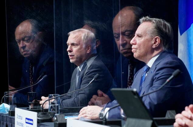 January 11, 2022, Montreal, PQ, Canada: Quebec Premier Francois Legault listens as interim Quebec Director of Public Health Dr. Luc Boileau responds to a question while Health Minister Christian Dube is reflected in the plexiglass barrier during a news conference in Montreal, Tuesday, Jan. 11, 2022. Montreal Canada  - ZUMAc35_ 20220111_zaf_c35_027 Copyright: xPaulxChiassonx