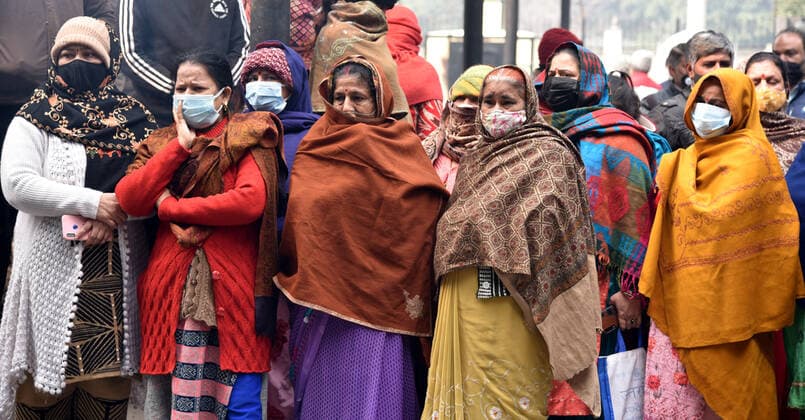 NEW DELHI, INDIA - JANUARY 13: Relatives and friends stand next to the funeral pyre of a person who died due to the Covid-19 coronavirus, disease at crematorium center Old Seema Puri Ghat, on January 13, 2022 in New Delhi, India. (Photo by Sonu Mehta Hindustan Times ) Daily Life Amid Coronavirus Pandemic In India