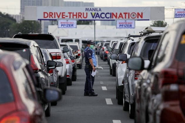 News Bilder des Tages January 14, 2022, Manila, Philippines: A traffic enforcer guides motorists lining up to receive COVID-19 vaccines at a drive-thru vaccination site in Manila, Philippines on January 14, 2022. Coronavirus infections continue to soar amid the governmentÃ¢â‚¬â ¢s strict enforcement of health protocols. Today, more than 37,000 cases were recorded; the highest since the pandemic started. Manila Philippines - ZUMAs213 20220114_zap_s213_004 Copyright: xBasilioxSepex