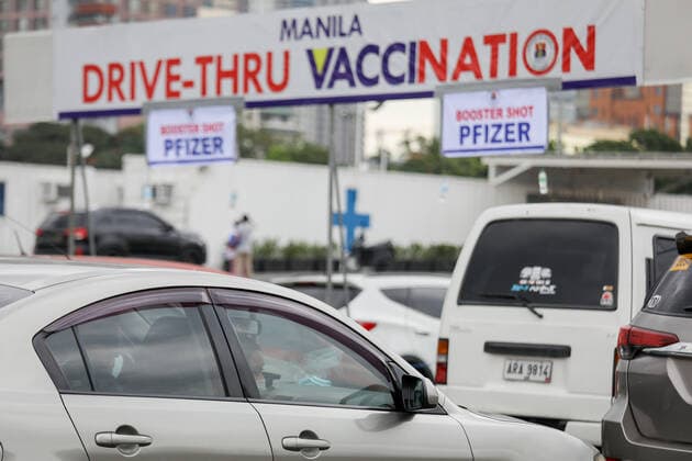 January 14, 2022, Manila, Philippines: A woman wearing a protective mask looks out from the window of a car as motorists line up to receive COVID-19 vaccines at a drive-thru vaccination site in Manila, Philippines on January 14, 2022. Coronavirus infections continue to soar amid the governmentÃ¢â‚¬â ¢s strict enforcement of health protocols. Today, more than 37,000 cases were recorded; the highest since the pandemic started. Manila Philippines - ZUMAs213 20220114_zap_s213_005 Copyright: xBasilioxSepex