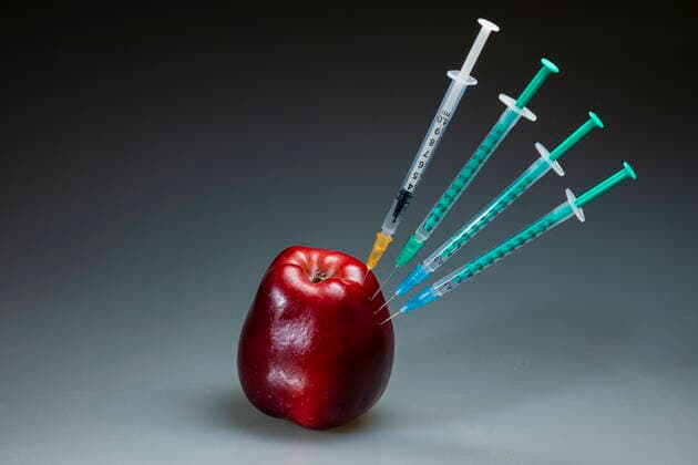 Covid motif symbol image vaccination a corona syringe is stuck in a red apple Bannewitz Saxony GERMANY