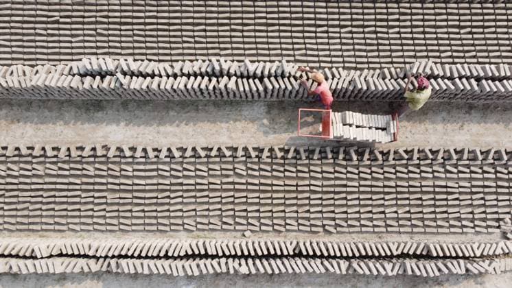 January 18, 2022, Narayanganj, Dhaka, Bangladesh: Workers are carrying bricks on a cart in a brick field in Narayanganj, Bangladesh. Bangladesh, with its 160 million inhabitants, is a country in constant demand for bricks as the primary material for construction of buildings in the era of urbanization. There are approximately 5000 privately operated brick kilns within Bangladesh, including 1000 around the capital, Dhaka. Brick kilns, indirectly responsible for climate change, emit toxic fumes containing large amounts of carbon monoxide, nitrogen oxide and oxides of Sulphur which are extremely harmful to the eyes, lungs and throat and causes environmental degradation. Brick labors work for 12-14 hours a day, six days a week, lacking basic hu - ZUMAs231 20220118_zip_s231_086 Copyright: xJoyxSahax