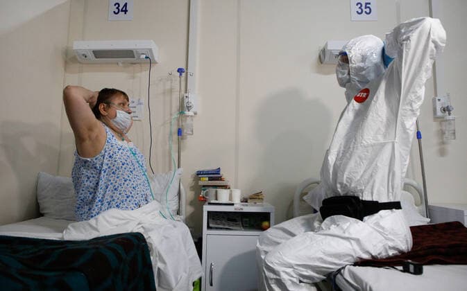 News Bilder des Tages Coronavirus in Russland, EindrÃ¼cke aus temporÃ¤rem Krankenhaus in St. Petersburg ST PETERSBURG, RUSSIA â€” JANUARY 20, 2022: A patient and a medical staff do physical exercises in the red zone of a field hospital for COVID-19 patients at the LenExpo Exhibition Centre. Since the start of the pandemic, St Petersburg has confirmed more than 897,800 cases of COVID-19. Since 15 January 2022, the number of new confirmed cases has been increasing in St Petersburg by more than 3,000 daily. On 20 January, St Petersburg reported a record high of more than 4,700 new coronavirus cases. With the advance of the omicron strain of coronavirus, the cityâ€™s health system has been put on high alert. Valentin Yegorshin TASS  TS11FD97