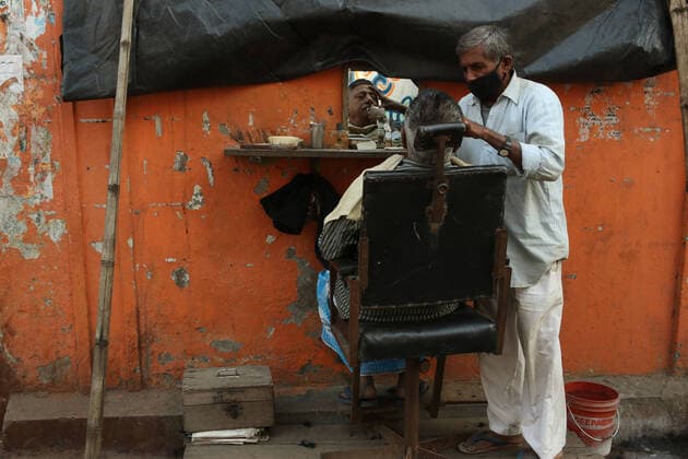 Coronavirus Emergency In India A roadside barber wearing face mask as a precaution against the coronavirus attends to a customer in Kolkata, Thursday on January 20,2022. Kolkata India  Copyright: xDebajyotixChakrabortyx originalFilename: chakraborty-notitle220120_npSoM.jpg