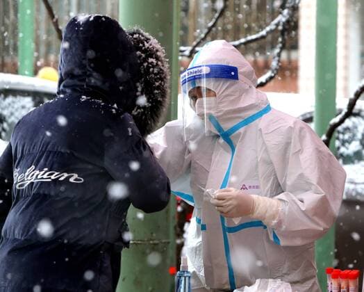 XI AN, CHINA - JANUARY 21: A medical member in protective suit collects a swab from a resident for the COVID-19 nucleic acid test in the snow on January 21, 2022 in Xi an, Shaanxi Province of China.  Copyright: xVCGx CFP111365844559