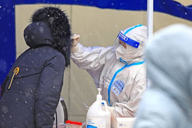 XI AN, CHINA - JANUARY 21: A medical member in protective suit collects a swab from a resident for the COVID-19 nucleic acid test in the snow on January 21, 2022 in Xi an, Shaanxi Province of China.  Copyright: xVCGx CFP111365844753