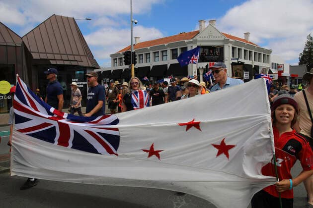 January 22, 2022, Christchurch, Canterbury, New Zealand: Protesters hold a New Zealand flag set upon an untraditional white background during the antivax protest in Merivale..Protesters take to the streets in the affluent suburb of Merivale in protest against the mandatory Covid19 vaccination. Christchurch New Zealand - ZUMAs197 20220122_zaa_s197_036 Copyright: xAdamxBradleyx