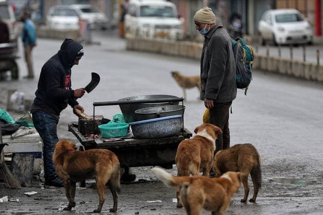 Weekend Lockdown In Jammu And Kashmir A vendor selling fish to a customer as Dogs wait for fish organs during COVID-19 Coronavirus weekend Lockdown on a cold winter day in Sopore, District Baramulla, Jammu and Kashmir, India on 22 January 2022. Sopore India  Copyright: xNasirxKachroox originalFilename: kachroo-notitle220122_npJIh.jpg