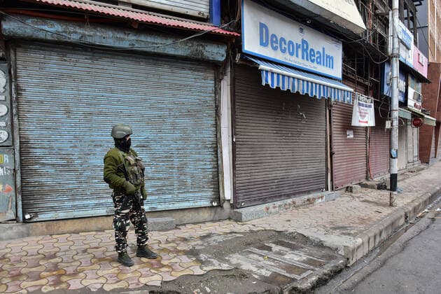 January 22, 2022, Srinagar, Jammu & Kas, India: A paramilitary trooper wearing a face mask stands alert at a closed market during a lockdown imposed by the authorities following the surge in coronavirus cases in Srinagar..Kashmir has been witnessing an exponential surge in Covid-19 cases following which authorities imposed a 64-hour lockdown to curb the surge. Jammu and Kashmir on Friday reported 5,720 coronavirus cases and five deaths. Meanwhile, India reported 337,704 new Covid-19 cases in the last 24 hours. Srinagar India - ZUMAs197 20220122_zaa_s197_047 Copyright: xSaqibxMajeedx