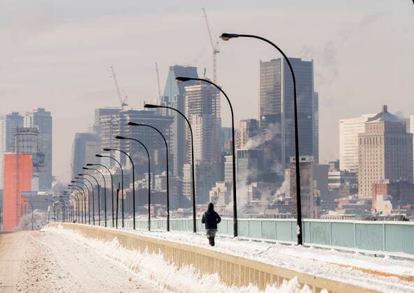 January 22, 2022, Montreal, PQ, Canada: A person jogs next to a backdrop of the Montreal skyline as ice fog rises off the St. Lawerence River in Montreal, Saturday, Jan. 22, 2022. Environment Canada has issued an extreme cold warning for the region. Montreal Canada  - ZUMAc35_ 20220122_zaf_c35_008 Copyright: xGrahamxHughesx