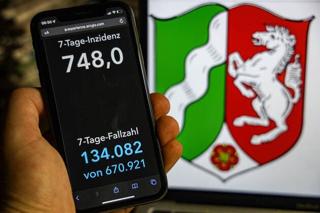 Coronavirus in Germany Covid 19 Dashboard of the Robert Koch Institute DEU, Germany, North Rhine Westphalia 23 01 2022 The 7-day incidence for the state Cases last 7 days 100 000 p.e. is displayed on an iPhone, with the state coat of arms in the background